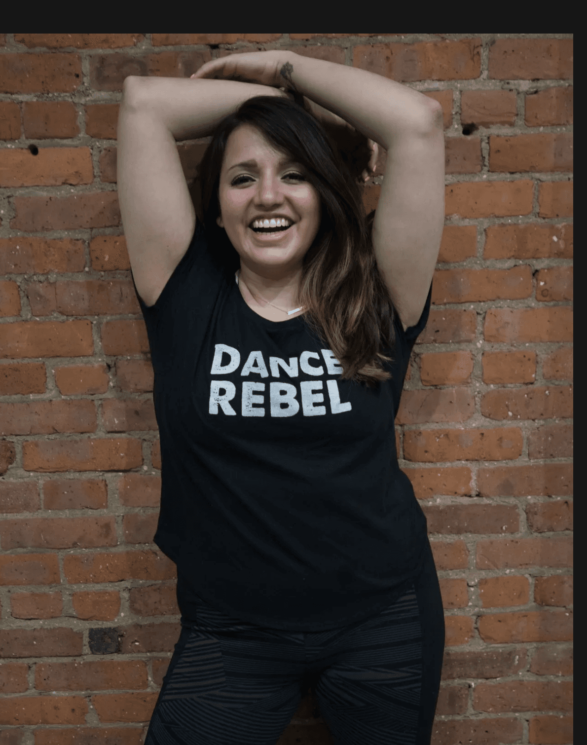 Dance Again student smiling in a Dance Rebel shirt