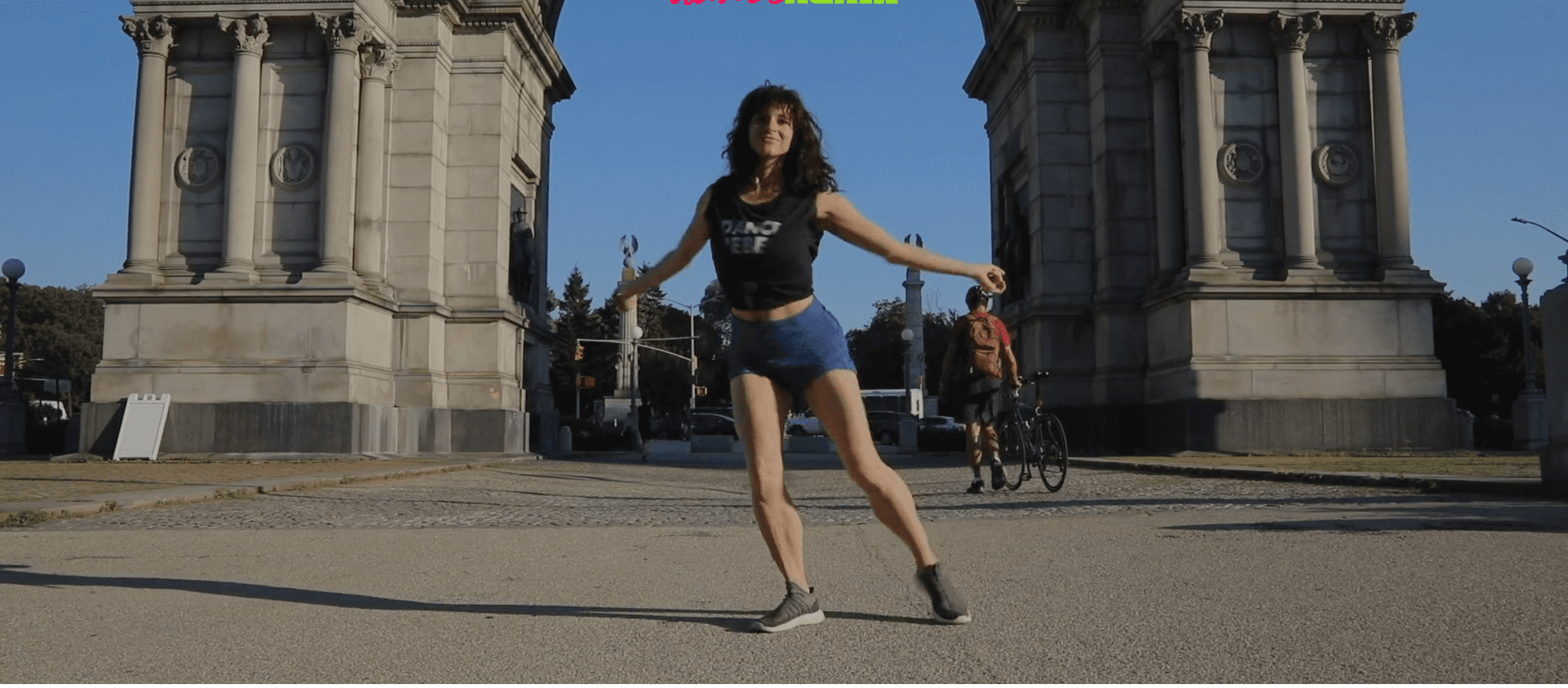 Jess dancing outside under a city arch